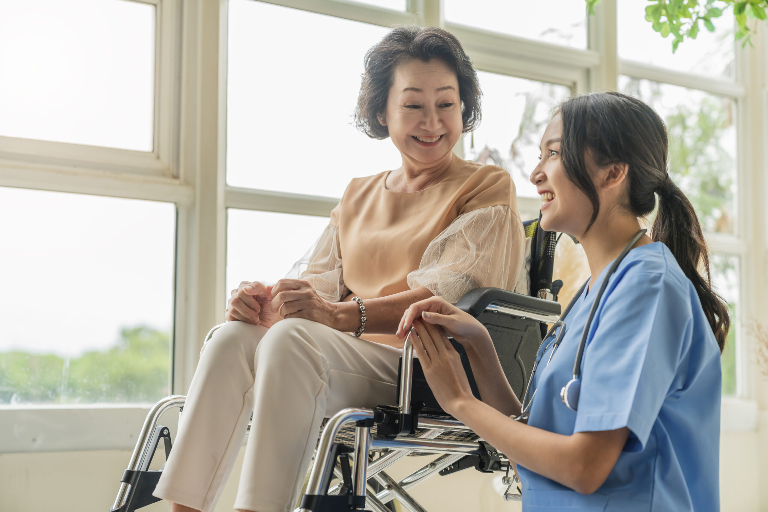 Caregiver assisting an elderly patient at home with mobility support